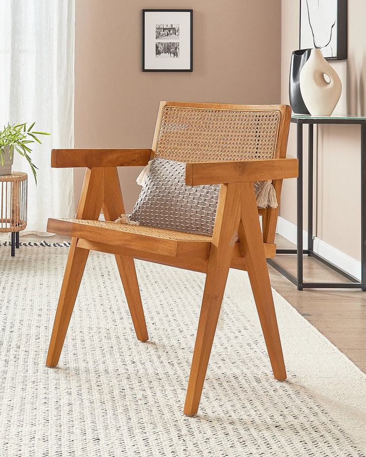 Wooden chair with woven rattan backrest and armrests in a modern indoor setting.