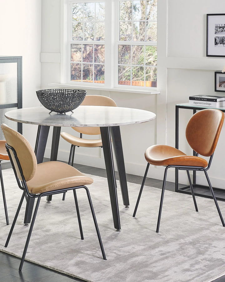 Styled around a round dining table, these modern upholstered chairs add comfort and sophistication, creating a warm and inviting dining space.
