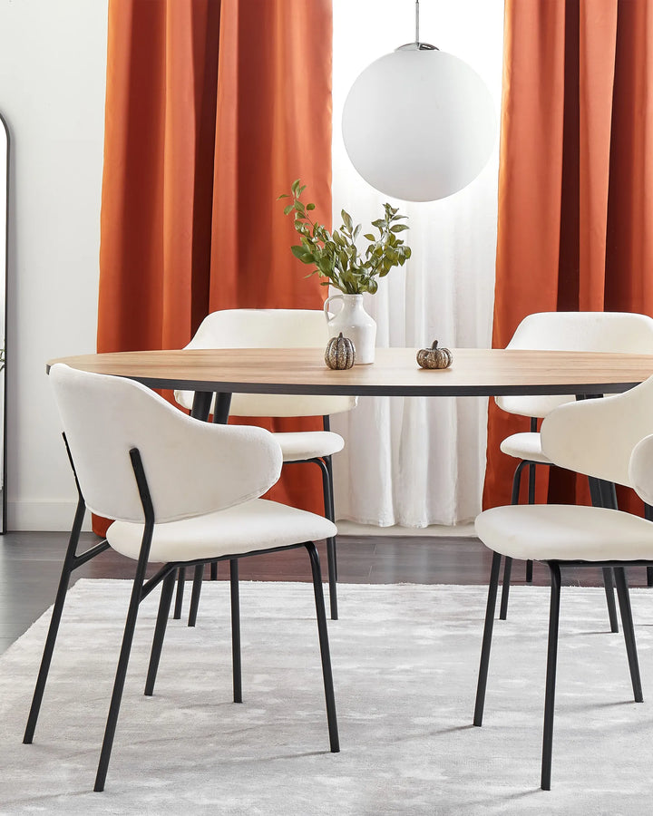 Cream boucle dining chairs around a wooden dining table with orange curtains and modern décor.