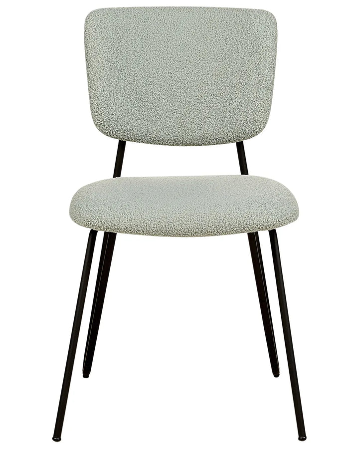 Light green bouclé dining chair with a softly padded seat and backrest, paired with slim black metal legs.