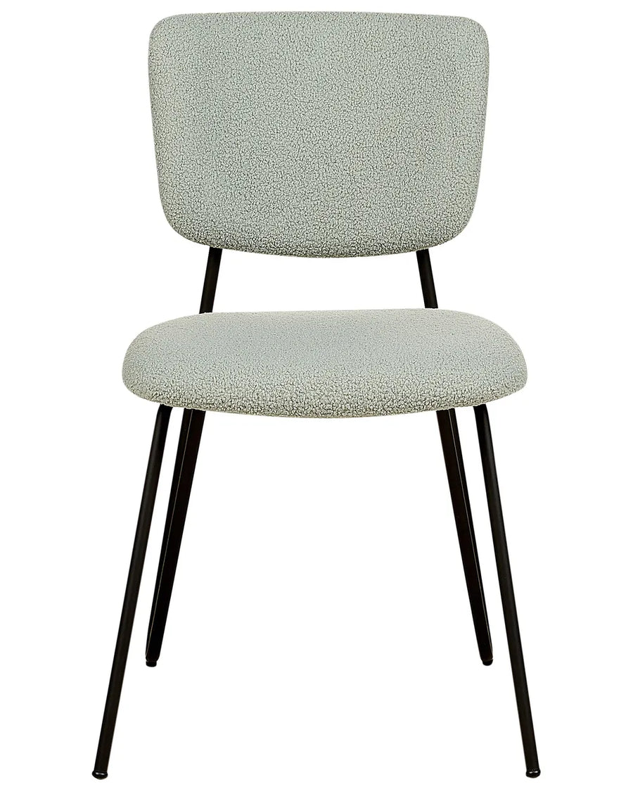 Light green bouclé dining chair with a softly padded seat and backrest, paired with slim black metal legs.