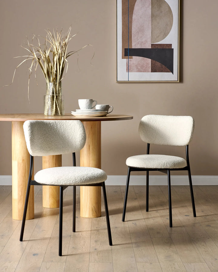 Contemporary dining space featuring cream bouclé chairs paired with a natural wood table, creating a warm and inviting modern aesthetic.