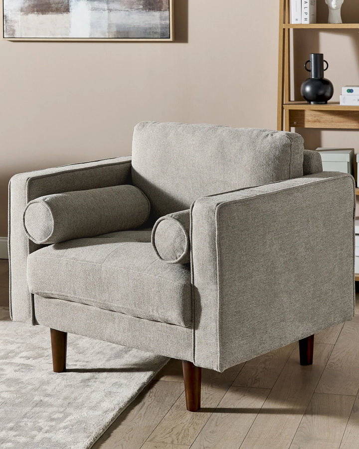 Gray armchair in a living room setting with a neutral color palette.
