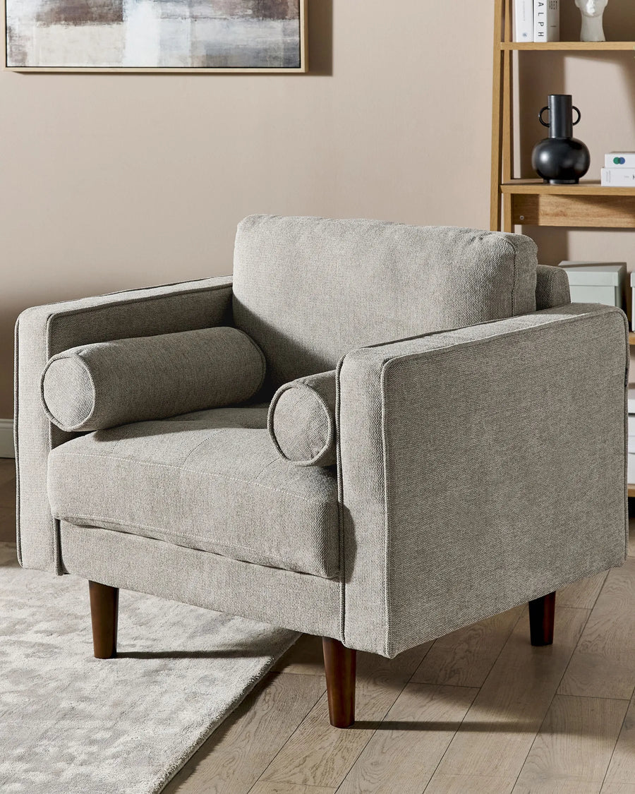 Gray armchair in a living room setting with a neutral color palette.