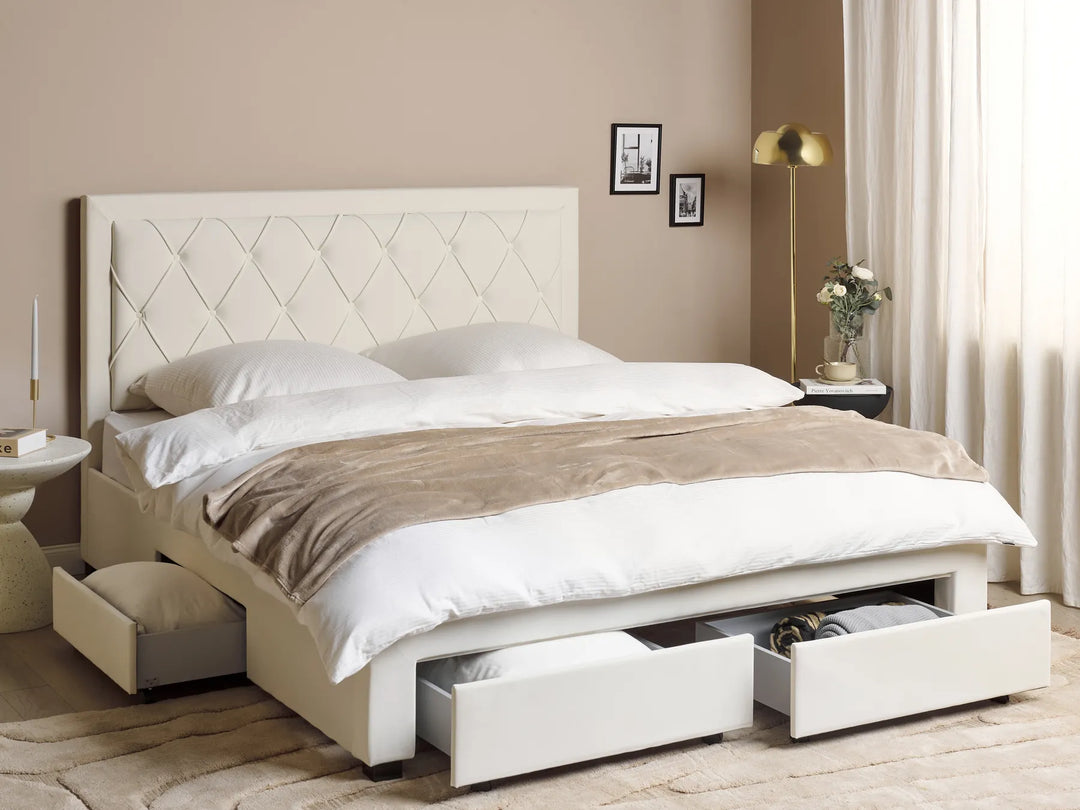 Beige upholstered bed with storage drawers in a bedroom setting.
