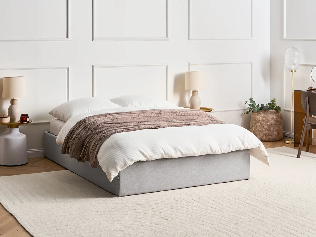 Bedroom with a neatly made bed, lamps, and decor 