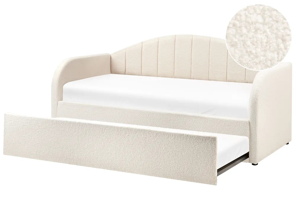 Beige upholstered bed with pull-out trundle on a white background