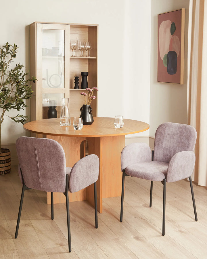 Elegant dining area featuring mauve accent chairs and warm wood furniture, creating a refined and inviting modern atmosphere.
