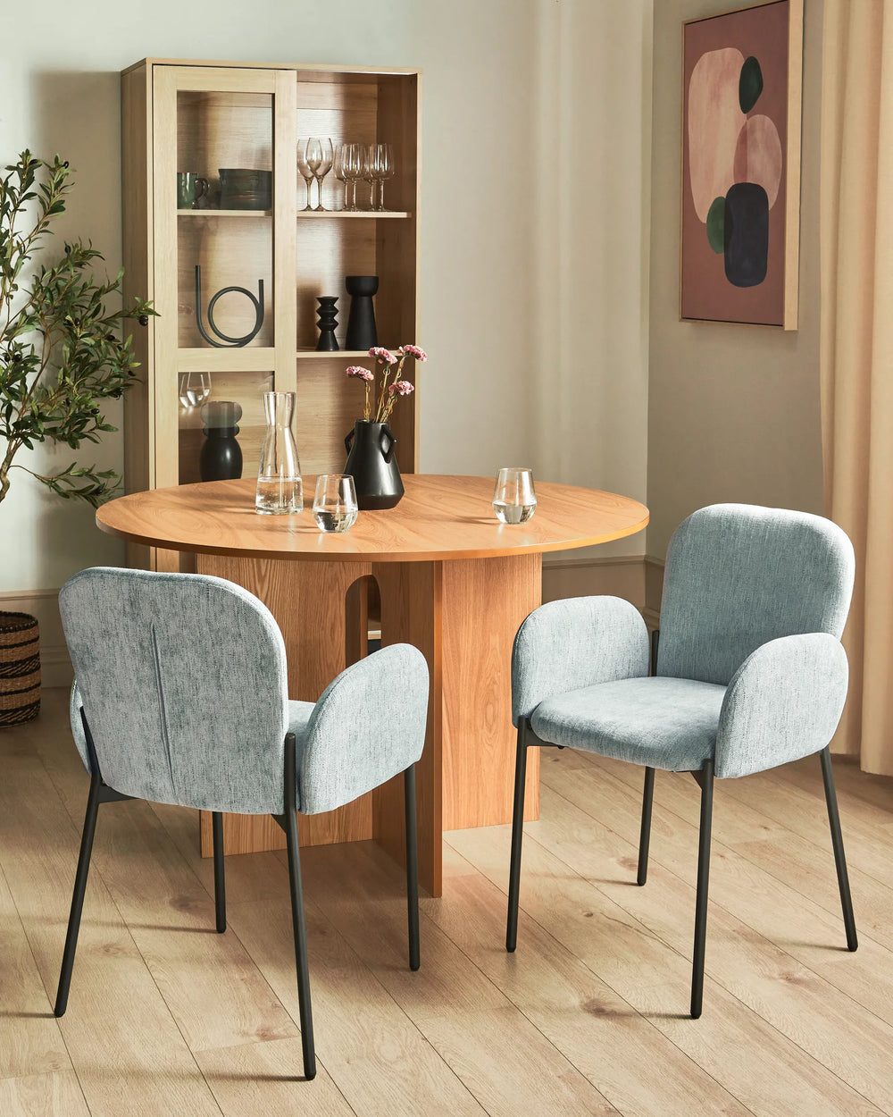 Bright contemporary dining space featuring light grey accent chairs and natural wood furniture, creating an airy and sophisticated atmosphere.