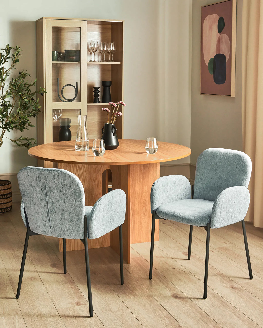 Bright contemporary dining space featuring light grey accent chairs and natural wood furniture, creating an airy and sophisticated atmosphere.