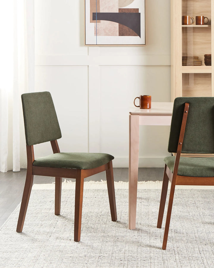 Walnut dining chairs with rich green upholstery styled in a warm, inviting dining setting, blending natural wood tones and soft textures to create a cozy, refined, and modern atmosphere.