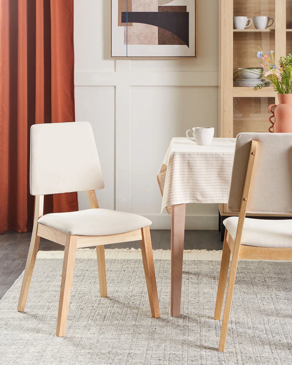 Light wood dining chairs styled in a bright, cozy dining setting, featuring neutral tones and soft textures that create a warm, inviting, and effortlessly modern atmosphere.