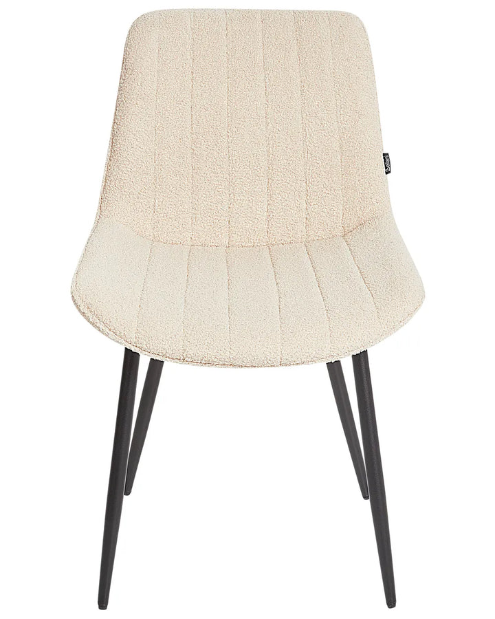 Cream bouclé dining chair with soft textured upholstery, subtle vertical stitching, and slim black metal legs for a modern, cozy look.