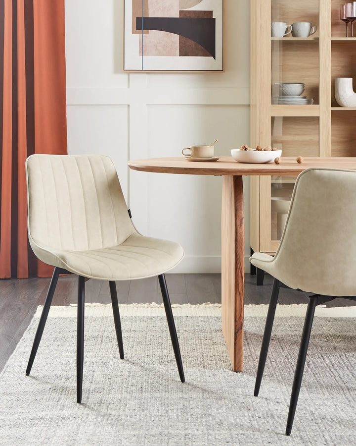 Elegant dining setup featuring the chair’s soft neutral upholstery, paired with natural wood furniture and warm accents to create a bright, contemporary atmosphere.