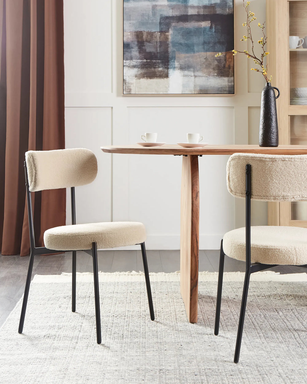 Cream bouclé dining chairs paired with a natural wood dining table, creating a warm and contemporary dining setting.