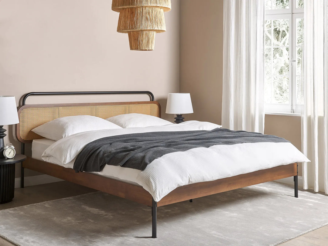 Wooden bed with white bedding and gray blanket in a bedroom setting.
