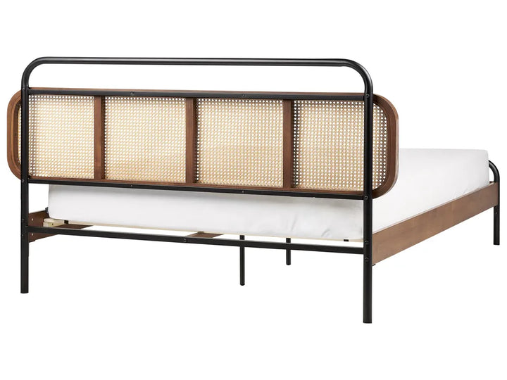 Bed with black metal frame and woven headboard on a white background
