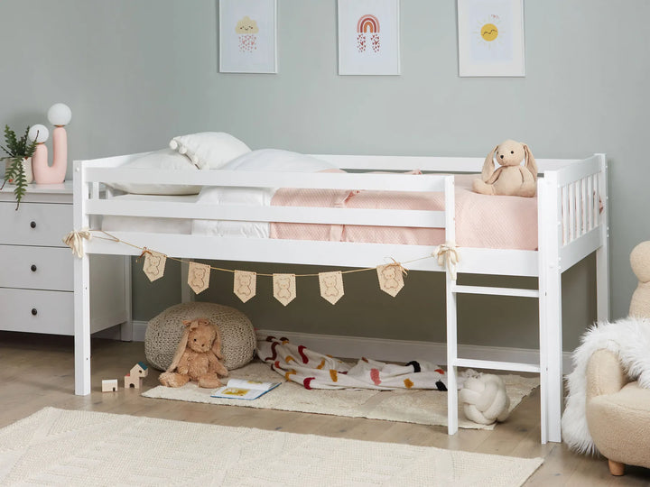 Children's room with a white bed, toys, and decorative elements.