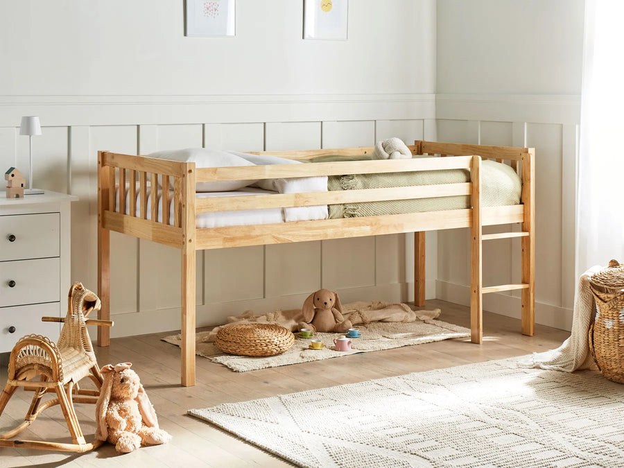 Wooden children's bed in a room with toys and furniture