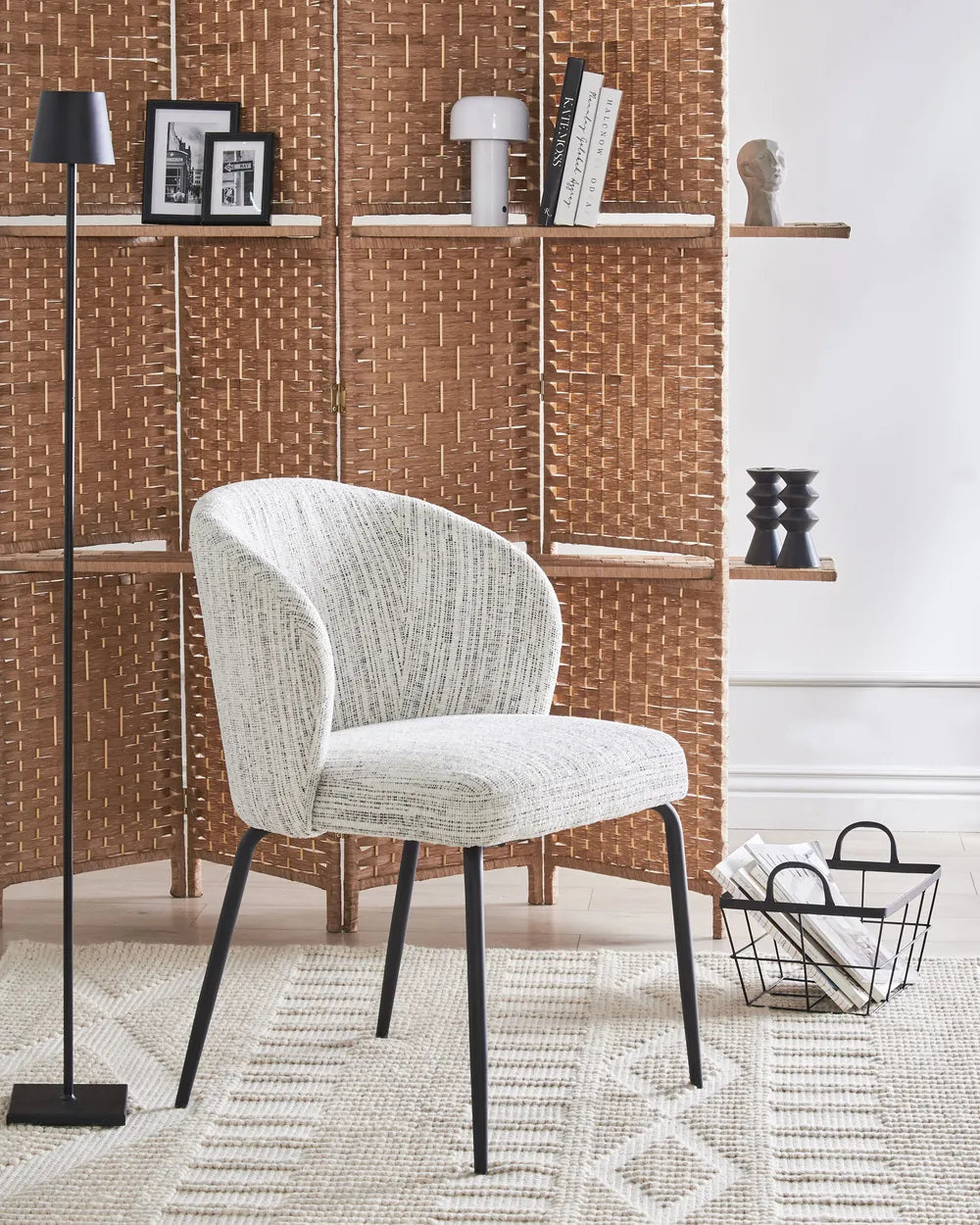 Contemporary interior showcasing the chair’s textured upholstery and sculpted silhouette, paired with black metal legs for a refined modern look.