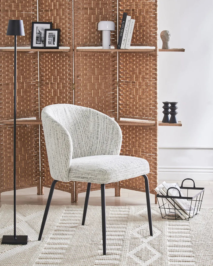 Contemporary interior showcasing the chair’s textured upholstery and sculpted silhouette, paired with black metal legs for a refined modern look.