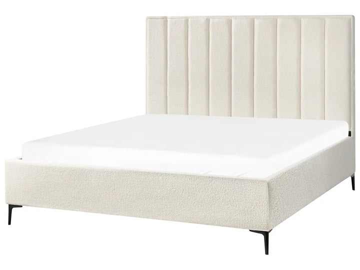 Beige upholstered bed with white mattress 