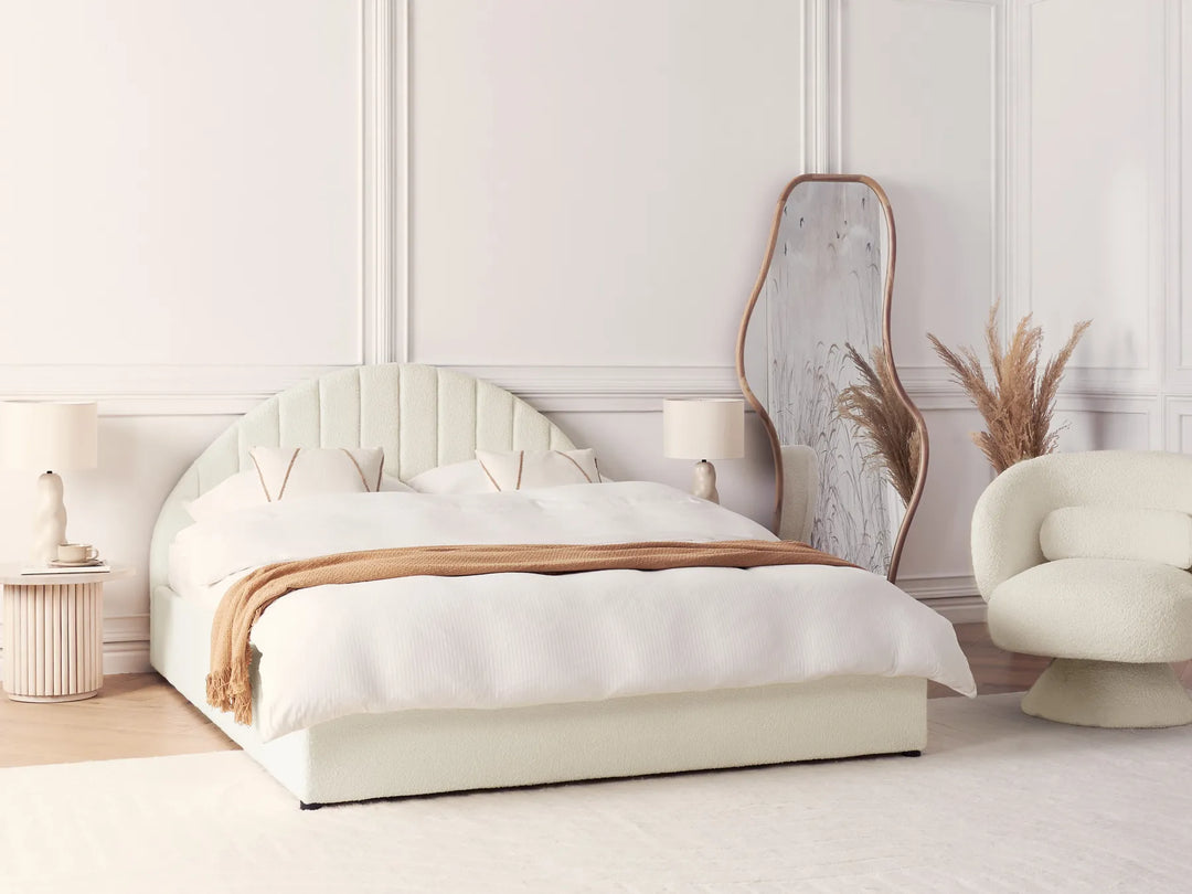 Modern bedroom with a white bed, mirror, and armchair.