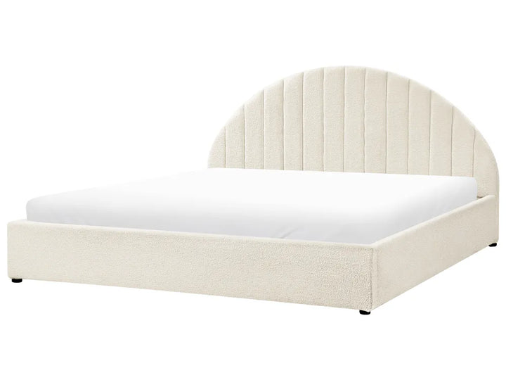 White bed with a curved headboard on a white background