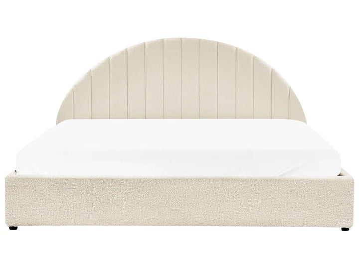 Beige upholstered bed with white bedding on a white background