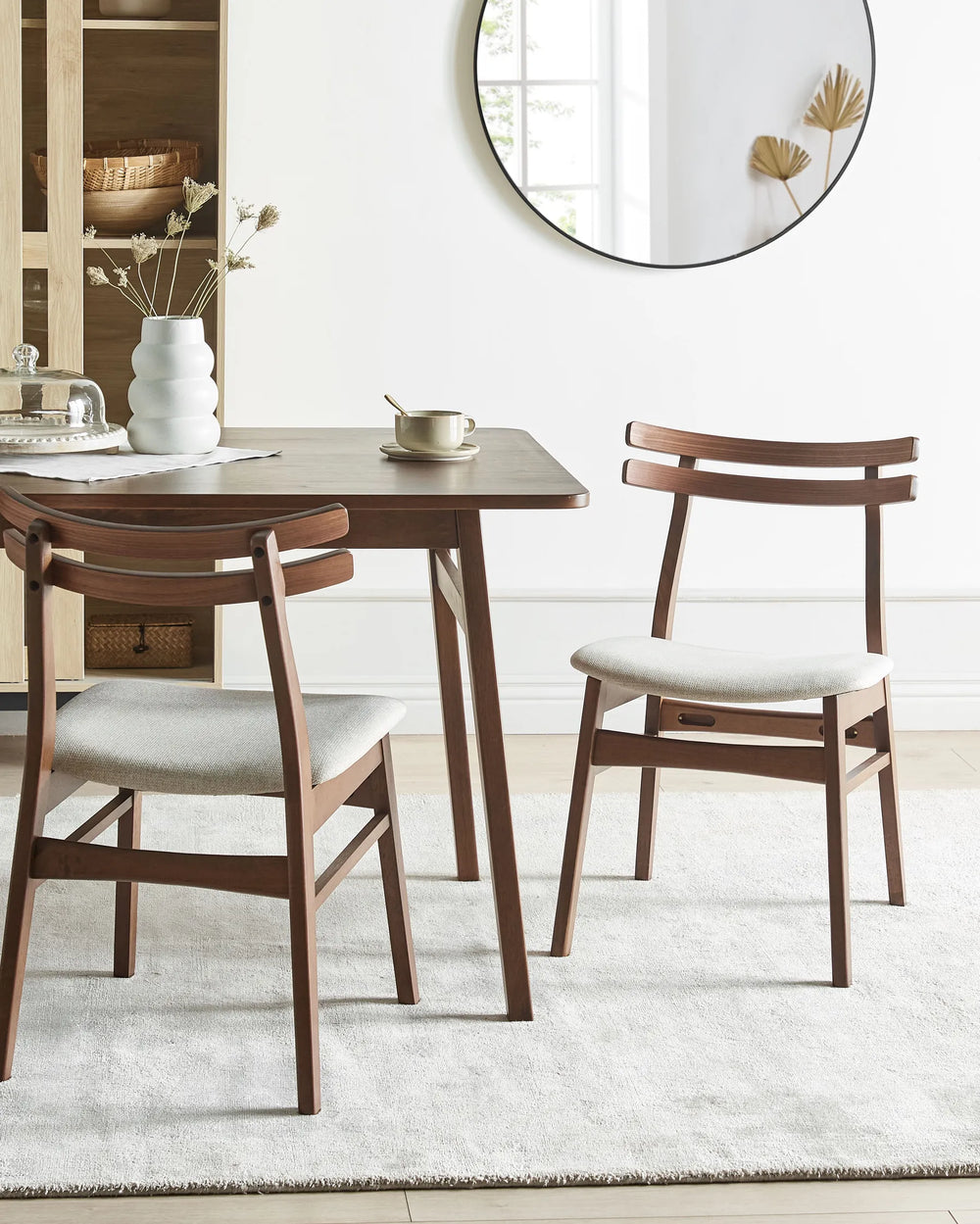 A set of dark wood dining chairs brings warmth and sophistication to the dining space, pairing clean architectural lines with soft neutral upholstery for a refined, inviting atmosphere.