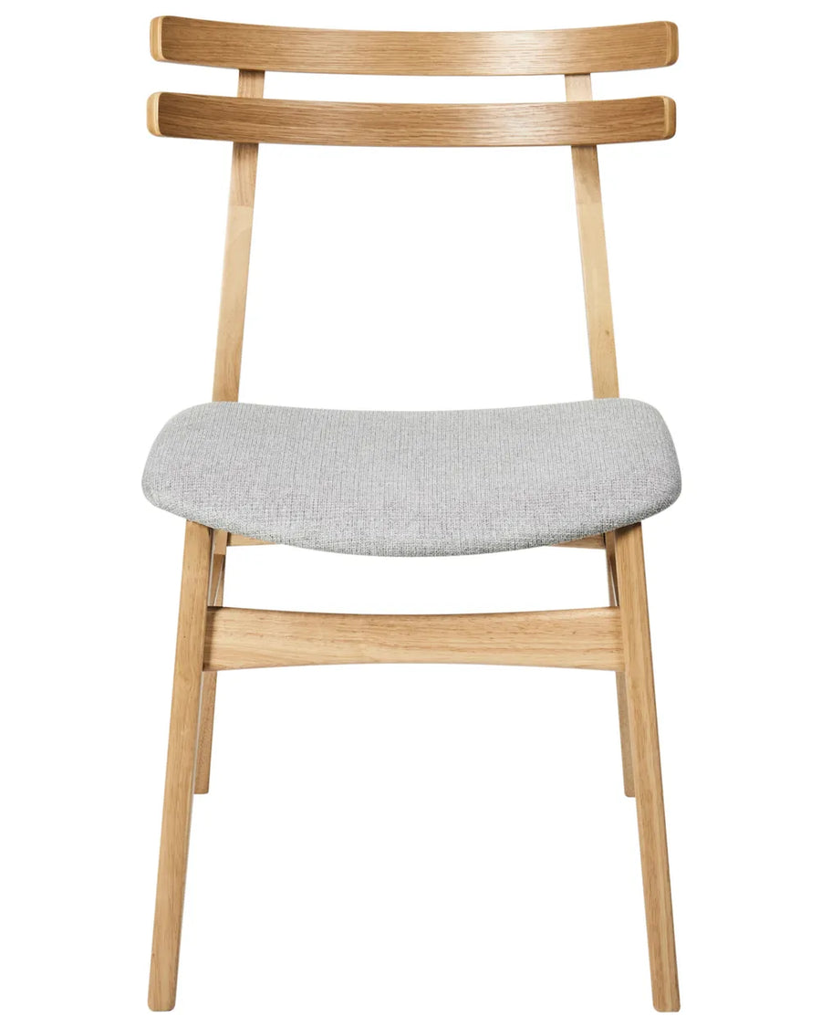 Contemporary dining chair featuring a light oak-effect frame, distinctive double-slat curved backrest, and a generously padded grey fabric seat. The clean lines and ergonomic design offer a perfect balance of comfort, durability, and Scandinavian-inspired style.