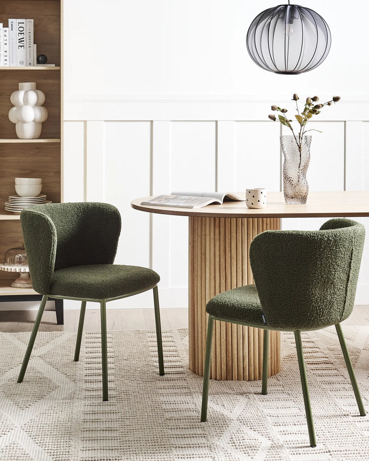 Modern dining setup featuring olive green bouclé chairs paired with a fluted wood table, bringing warmth, texture, and contemporary elegance to the space.