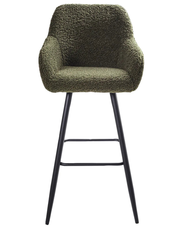 Dark green bouclé bar chair with a rounded upholstered backrest, padded seat with integrated armrests, and slanted black metal legs.