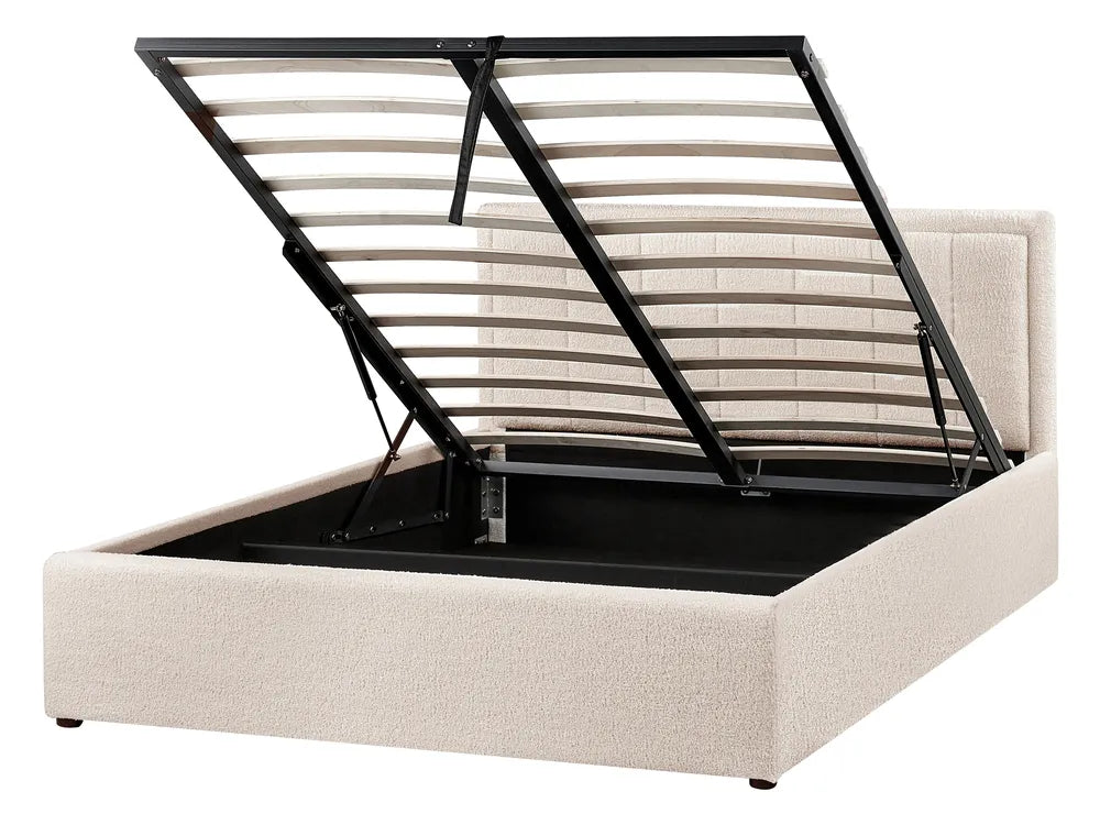 Beige upholstered bed frame with black metal slat support on a white background