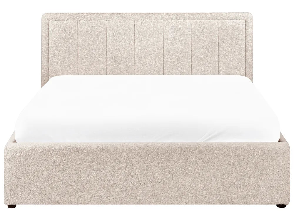 Beige upholstered bed with white mattress on a white background