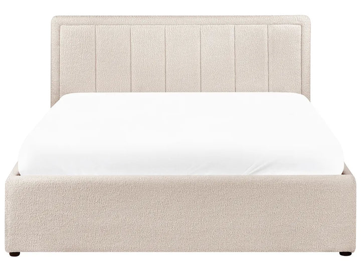 Beige upholstered bed with white mattress on a white background