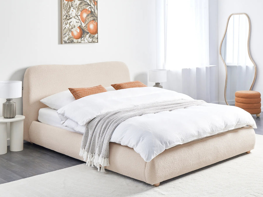 Beige upholstered bed with white bedding in a modern bedroom setting.