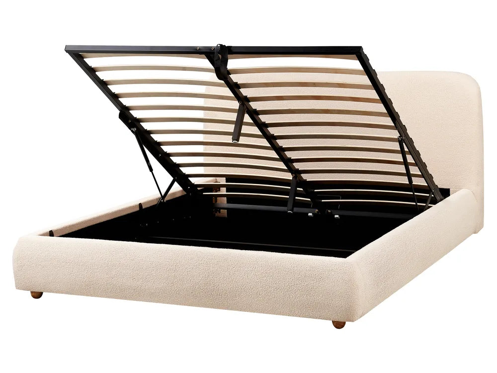 Beige upholstered bed with black metal frame on a white background