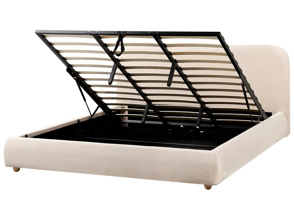 Beige upholstered bed with black metal frame on a white background
