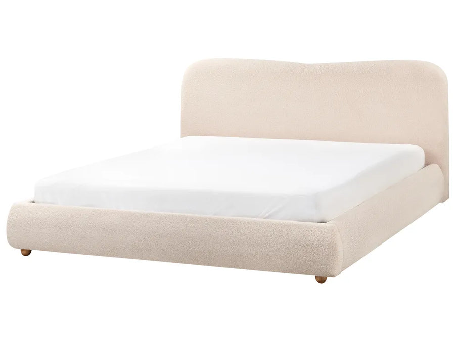 Beige upholstered bed with white mattress on a white background