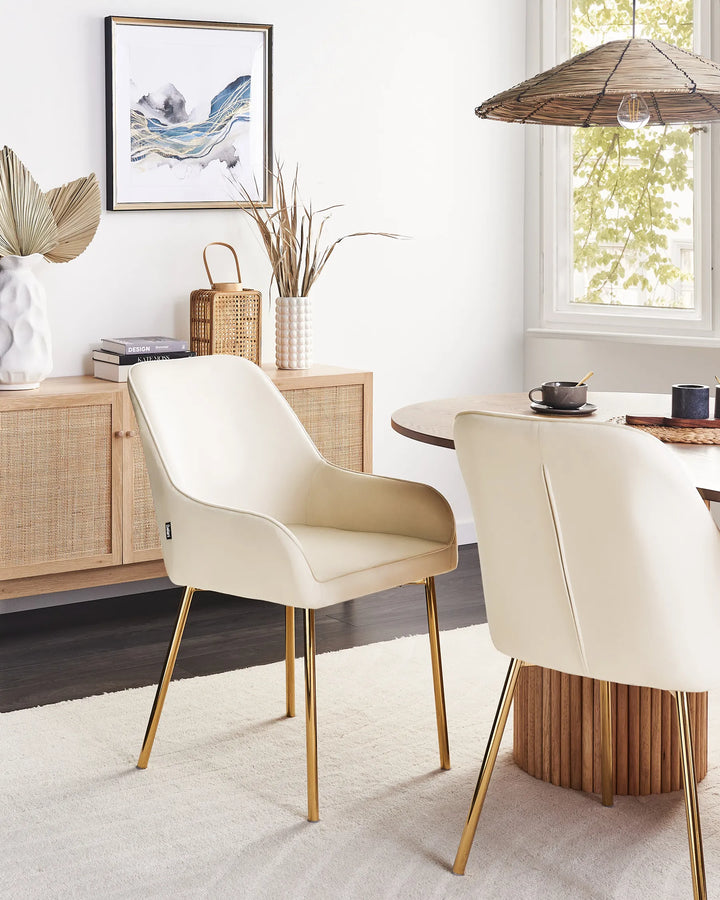 Contemporary dining space featuring cream dining chairs with gold accents, creating a bright, luxurious atmosphere that pairs beautifully with natural wood and warm-toned décor.