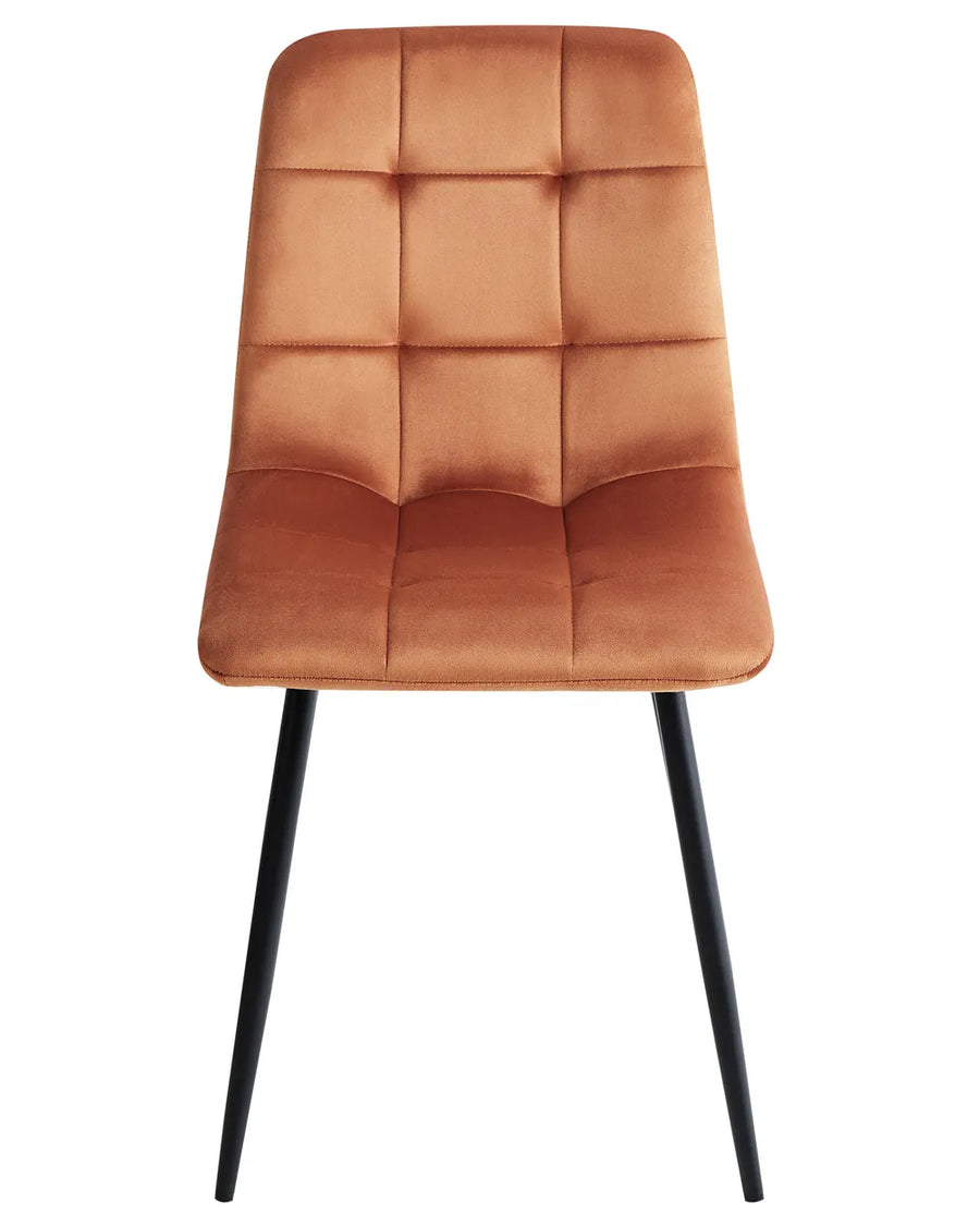 Velvet dining chair in warm caramel brown with quilted square stitching, a padded high backrest, and slim black metal legs.