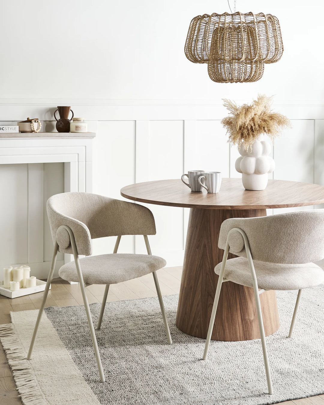 Light beige chenille dining chairs with curved backrests, integrated armrests, and matching metal frames arranged around a dining table in a bright, modern dining space with minimalist décor.
