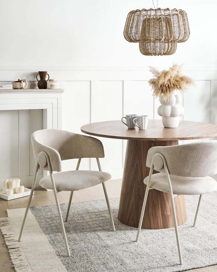 Light beige chenille dining chairs with curved backrests, integrated armrests, and matching metal frames arranged around a dining table in a bright, modern dining space with minimalist décor.