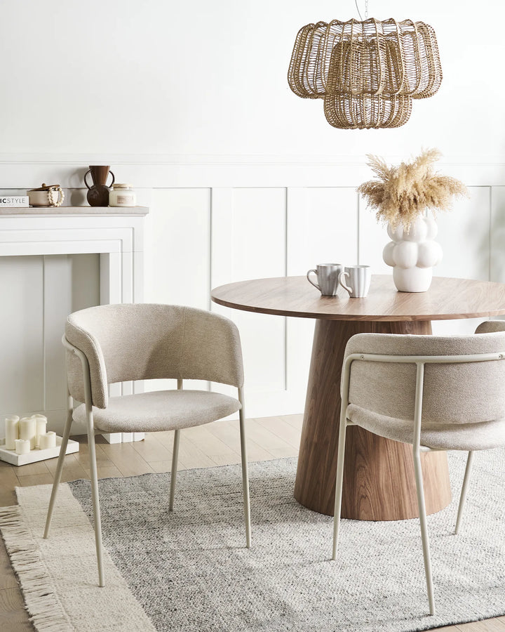 Elegant dining setting featuring beige bouclé chairs paired with warm wood accents and neutral décor, creating a cozy and sophisticated atmosphere.