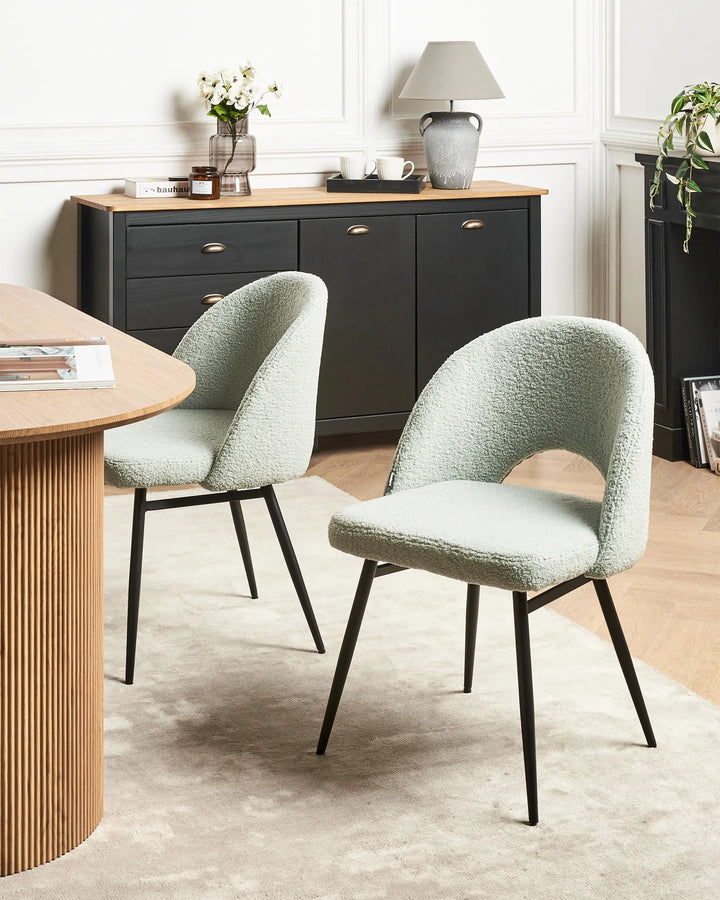 Sage green bouclé chairs styled around a contemporary wood dining table, creating a soft and elegant dining space.