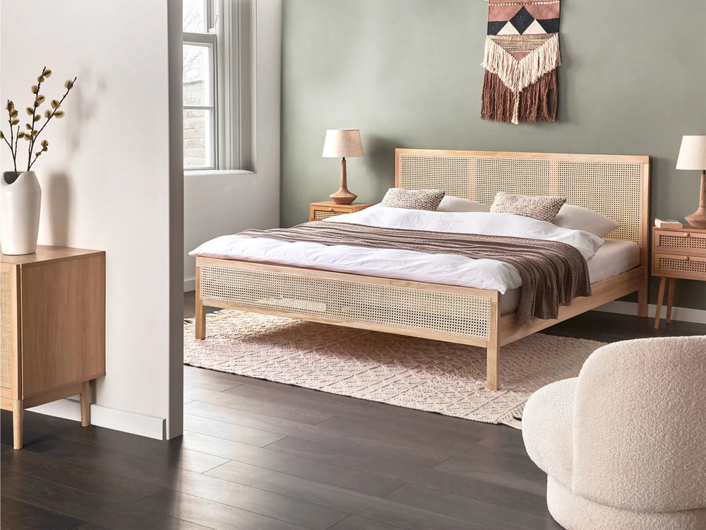 Bedroom with wooden bed and side tables, featuring a lamp and decorative items.