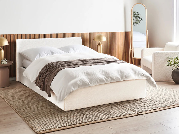 Modern bedroom with a bed, lamps, and a mirror.