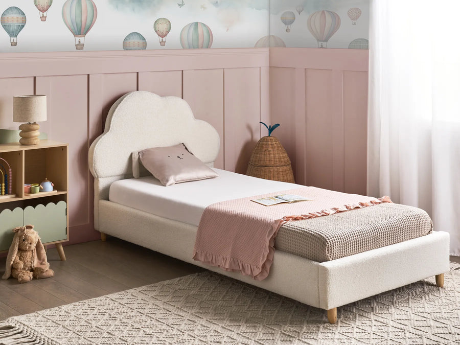 Children's bedroom with a white bed, pink headboard, and colorful hot air balloon wallpaper.