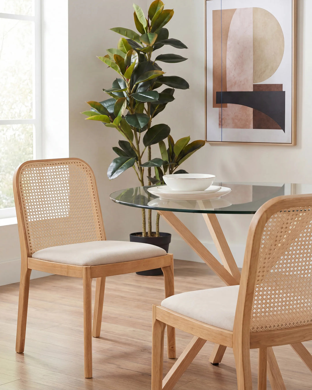 Bright dining space featuring rattan-back chairs and a glass-top table, creating a warm and relaxed natural aesthetic.